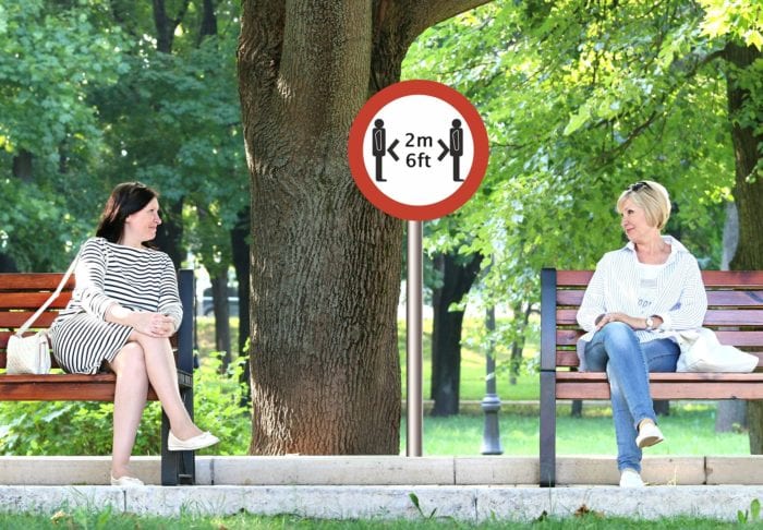 social distance sign and two women