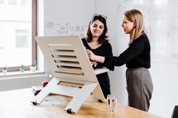 two women standing at a desk 